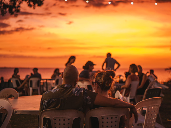 Couple sitting in an embrace watching the sunset at Darwin Ski Club