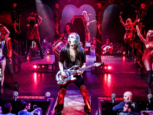 a man with a guitar performing at the Draculas Cabaret