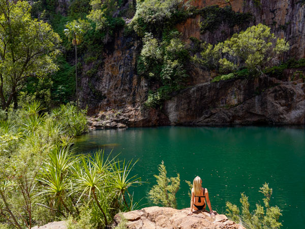 a woman sitting on a rock at Emma Gorge, El Questro Wilderness Park