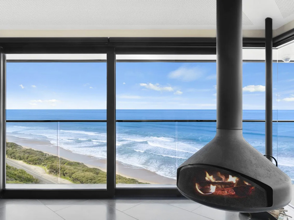 a fireplace near the full-length glass windows at The Pole House Fairhaven