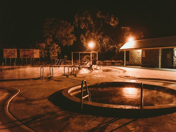 People enjoying a soak in the Artesian Bore Baths in Lightning Ridge, open 24 hours a day. (Image: Destination NSW)