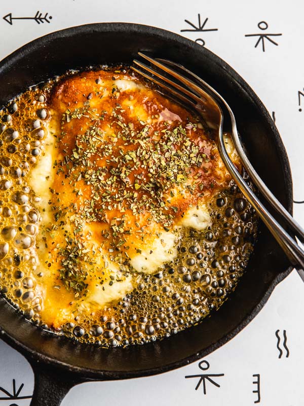 Saganaki cheese sizzling in pan at Greca in Brisbane