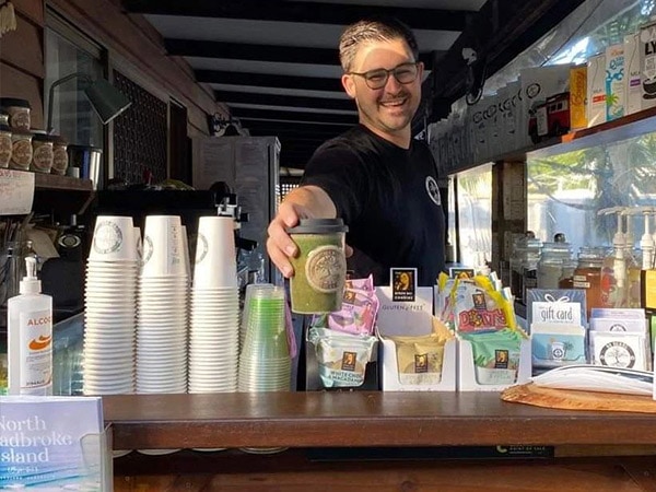 Bo hands out coffee at Bo Beans café on North Stradbroke Island, Brisbane.