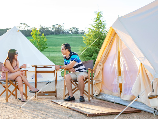 a couple enjoying their coffee outside the glamping tent at Mayfield Garden, Oberon