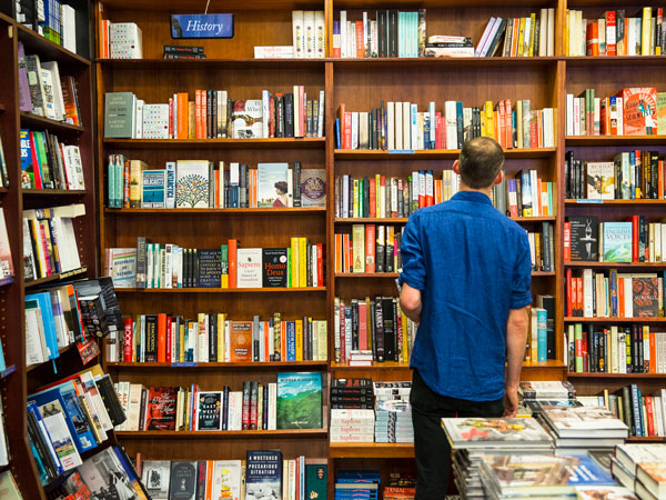 a man picking books at Readings Carlton