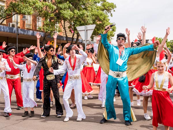 Elvis impersonators and crowds gather at the annua Street Parade in Parkes.
