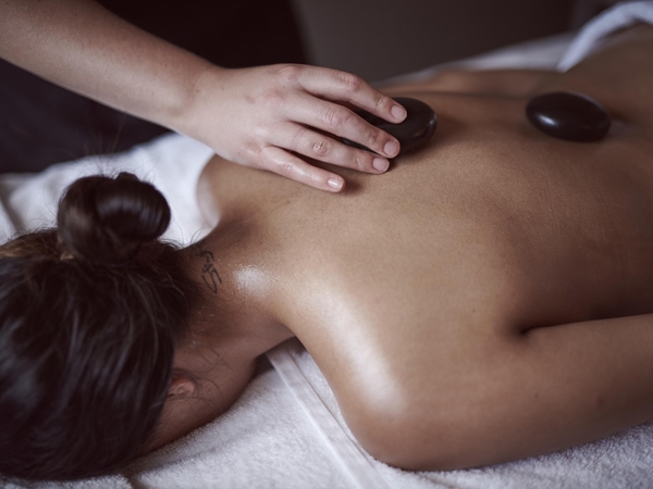a woman lying on her back face down while having a massage at Elysia Retreat
