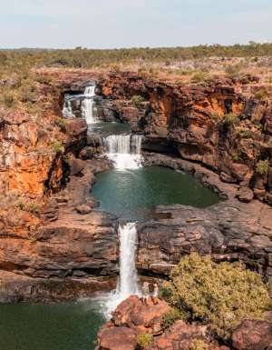 Two people standing at Mitchell Falls in the Kimberley (Image: Tourism Australia)