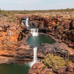 Two people standing at Mitchell Falls in the Kimberley (Image: Tourism Australia)