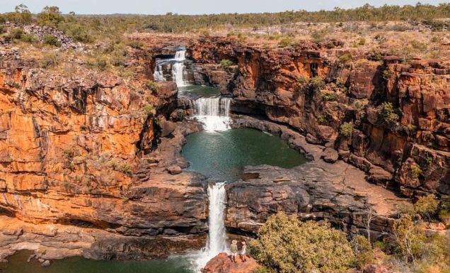 Two people standing at Mitchell Falls in the Kimberley (Image: Tourism Australia)