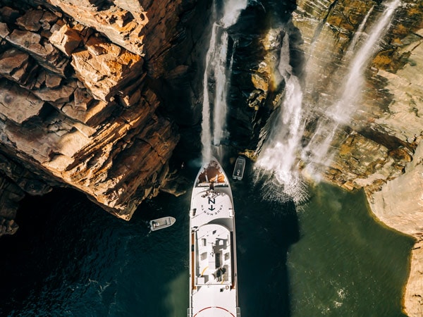 the True North cruise ship making a stop over at a scenic waterfall in Kimberley