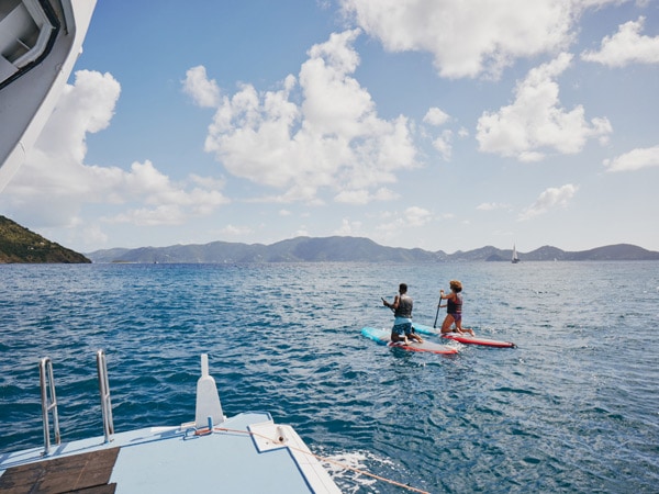 two people gliding through the waters on a paddle board