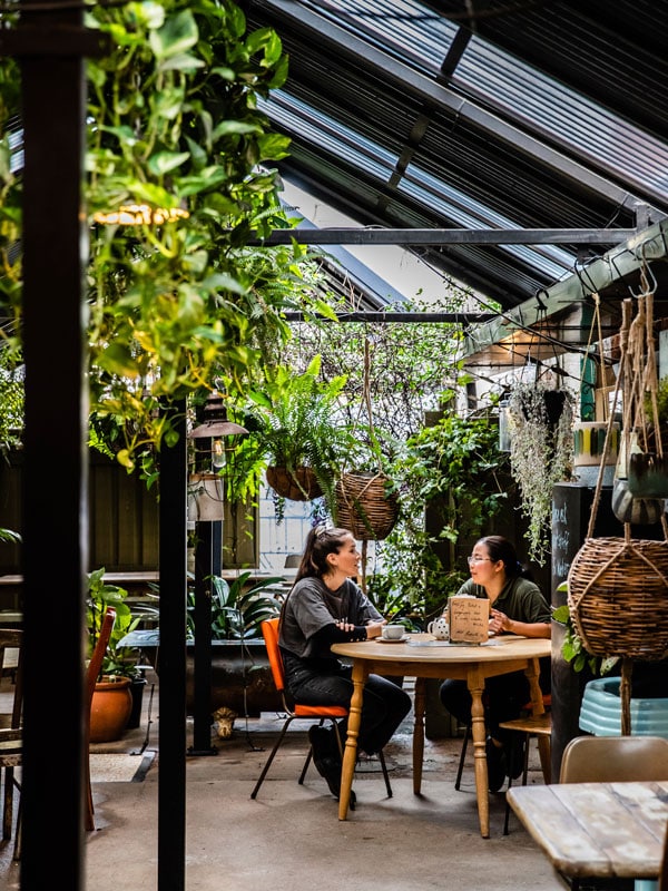 two people sitting inside a cafe at Worn Out Wares, Singleton