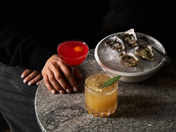 cocktail glasses alongside a plate of oysters at arkhé, Adelaide