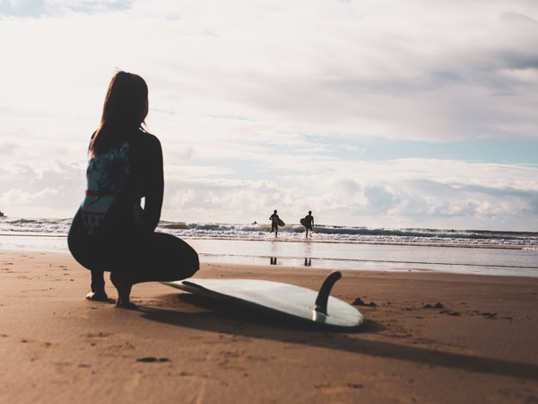 Surfers heading out for a morning surf at Turners Beach, Yamba.