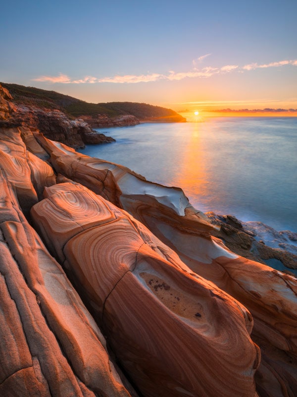 orange-hued rocks along Bouddi Coastal Walk at sunset