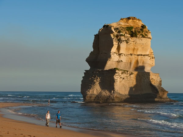 walking past a huge limestone stack at the Twelve Apostles, Great Ocean Walk