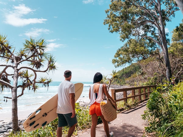 two people holding surfboards along the Noosa Coastal Walk