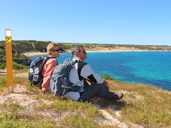 an old couple sitting atop the Walk the Yorke trail while admiring ocean views