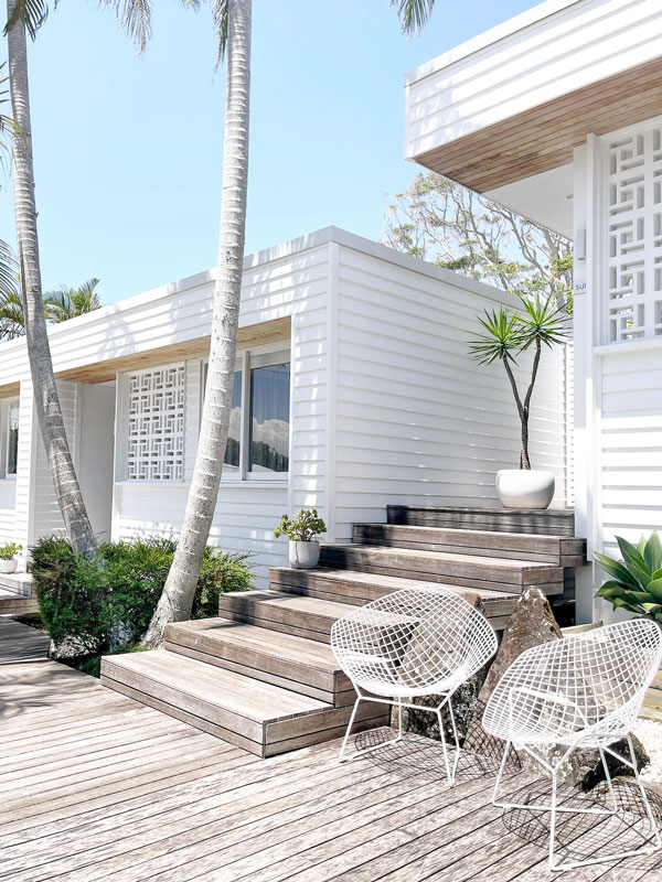 white-painted exterior with outdoor chairs at Bask & Stow