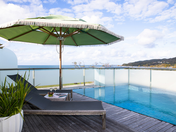 sunlounger and umbrella by the pool at Beach Suites, Byron Bay