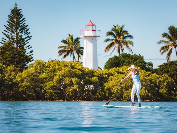 A woman on a paddle on the water.