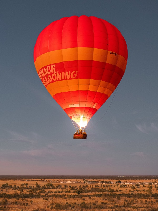 Soar above the majestic MacDonnell Ranges on a hot-air balloon. (Image: Tourism NT and Plenty of Dust)