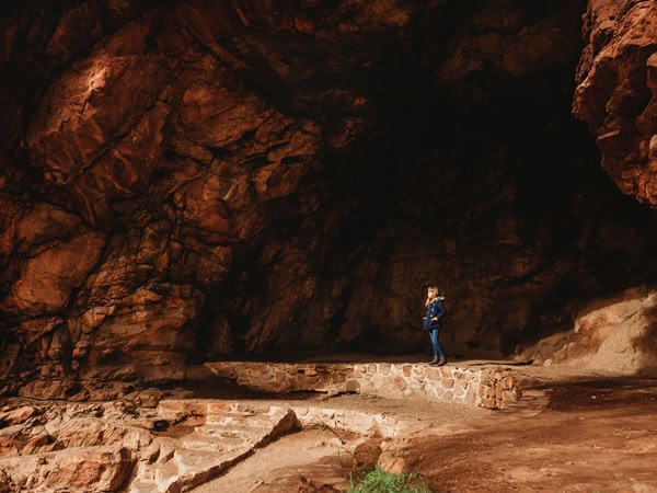 a woman standing at a cave entrance in Morialta Conservation Park