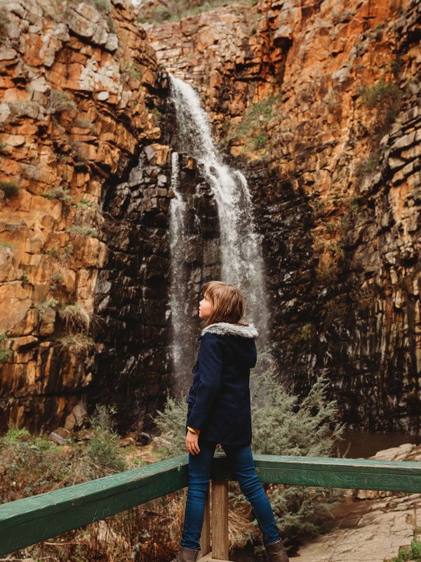 a kid standing in front of a waterfall at Morialta Conservation Park
