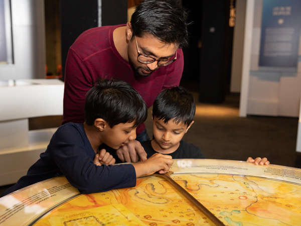 two young boys with their father exploring the artefacts at the Eureka Centre Ballarat