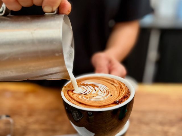 pouring milk over coffee at King of the Castle Cafe