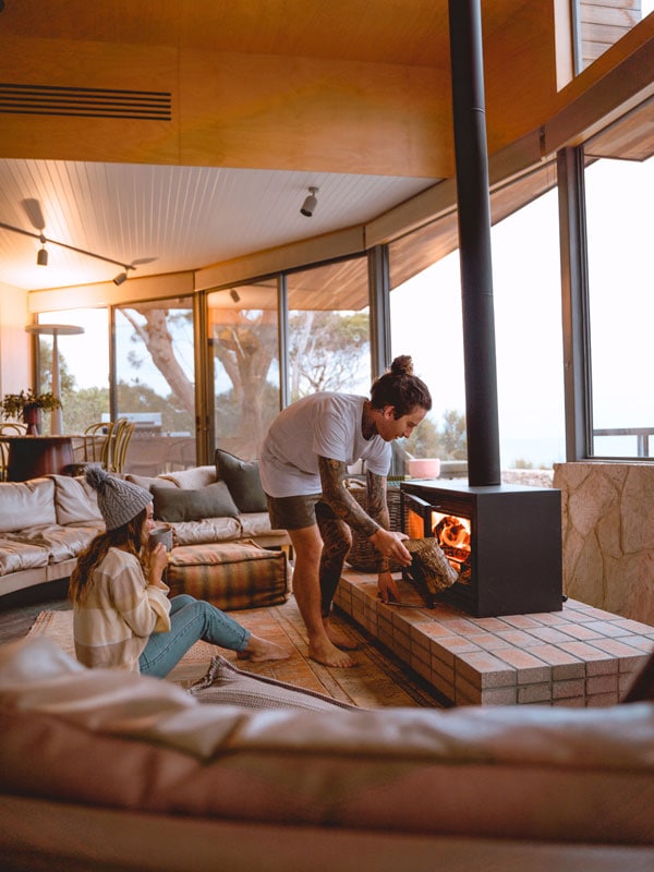 Couple sit next to the fire at Hamilton & Dune. 