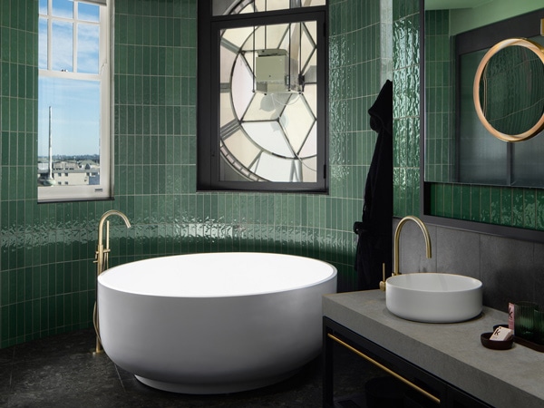 the clock suite bathroom in QT Newcastle with a bathtub