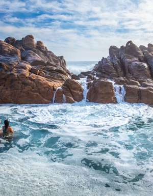 Girls swim in the natural rock pools at Injidup Beach in Yallingup.
