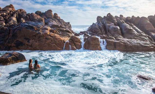 Girls swim in the natural rock pools at Injidup Beach in Yallingup.