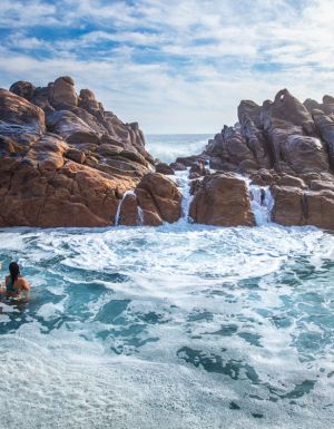 Girls swim in the natural rock pools at Injidup Beach in Yallingup.