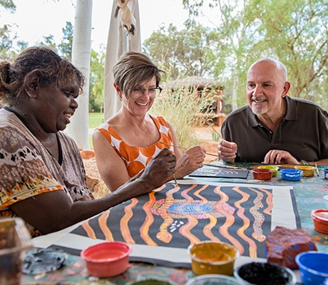 Artist teaching couple to dot paint