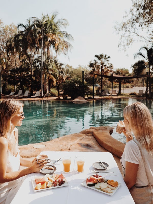 two girls eating breakfast by the pool at Cooinda Lodge