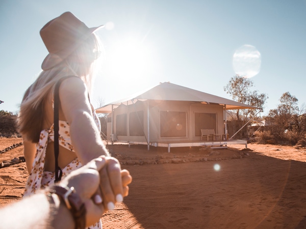a couple holding hands as they enter the Kings Canyon Resort glamping tent, Northern Territory