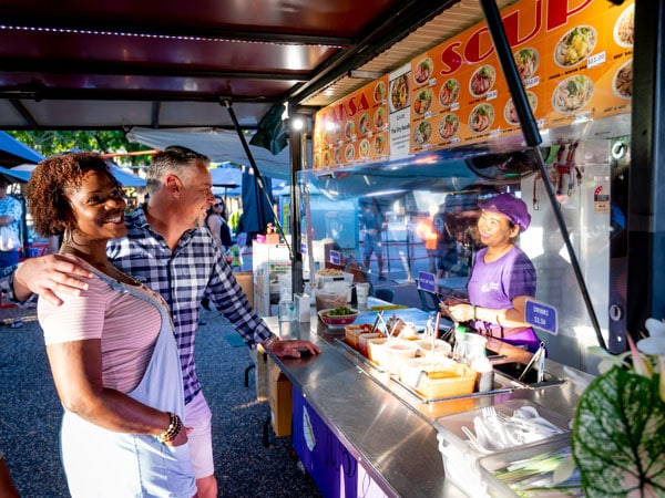 a couple buying Laksa soup at Parap Village Markets