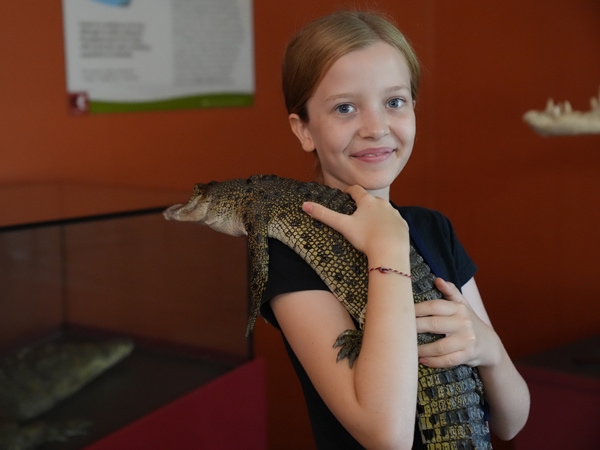 a child holding a baby croc 