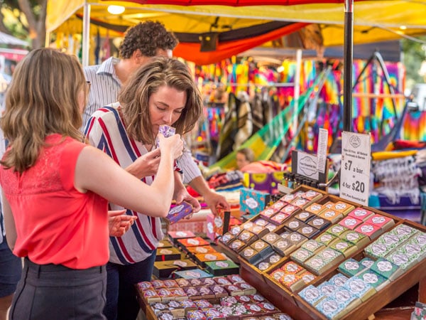 a person smelling soap at a stall in Mindil Beach Sunset Market