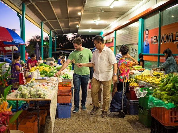 two people browsing through stalls selling fresh produce at Rapid Creek Markets