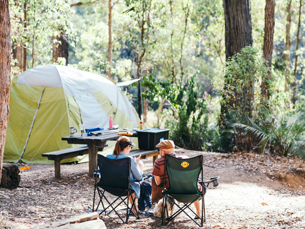 a couple sitting outside their tent, Perth