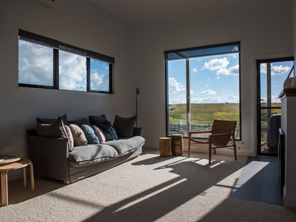 sunlight peeking through the windows of the living room at Dragonfly Cottages