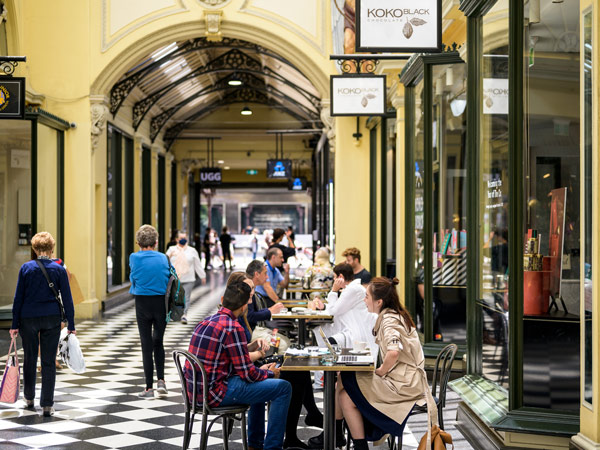 people sitting outside Koko Black chocolate shop in The Royal Arcade on Bourke Street