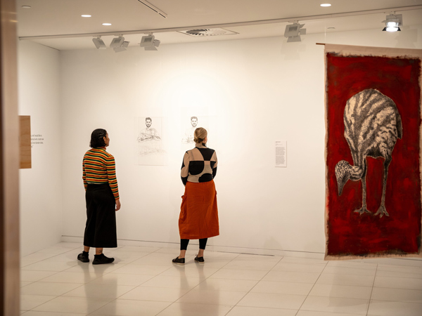 two people standing side by side while staring at an artwork inside Koorie Heritage Trust