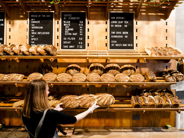 a woman picking up bread at To Be Frank Bakery, Melbourne
