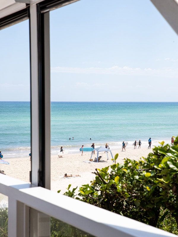 view of people at the beach from Beach Byron Bay cafe