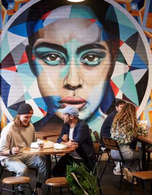 people dining near a vibrant wall art in Adelaide Central Market